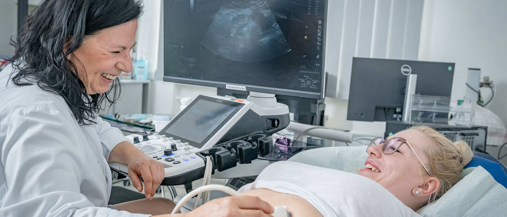Die Chefärztin Frau Porf. Dr. Schlosser untersucht eine Patientin mittels Ultraschall. Im Hintergrund sieht man das Ultraschallbild.