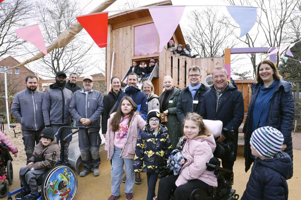 ChatGPT: Feier zur Eröffnung des neuen inklusiven Spielplatzes der Mira Lobe Schule: Förderer, Schulleitung und weitere Beteiligte stehen zusammen mit vielen Kindern mit und ohne Behinderung auf dem Schulhof. Die Atmosphäre ist fröhlich, es wird gelacht, gesprochen und gemeinsam gefeiert.