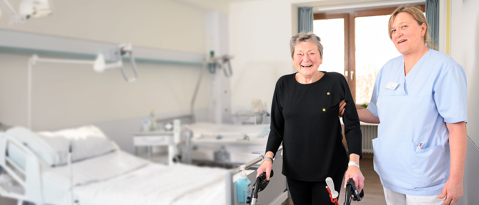 Pflegerin, die eine ältere Patientin am Rollator begleitet